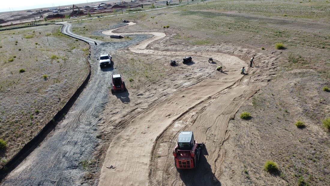 Aerial view of crews and skid steers stabilizing a drainage channel