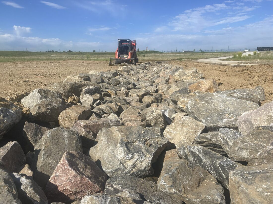 Riprap installed with a skid steer for scour mitigation